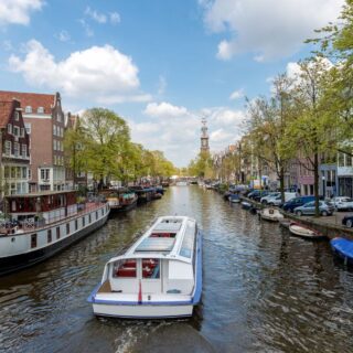 View of a boat cruising through the canals of Amsterdam.
