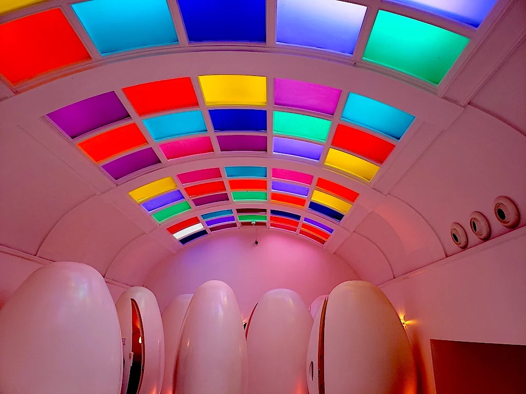Spaceship like bathroom inside Sketch with egg shaped pod toilets and a multi-color roof. 