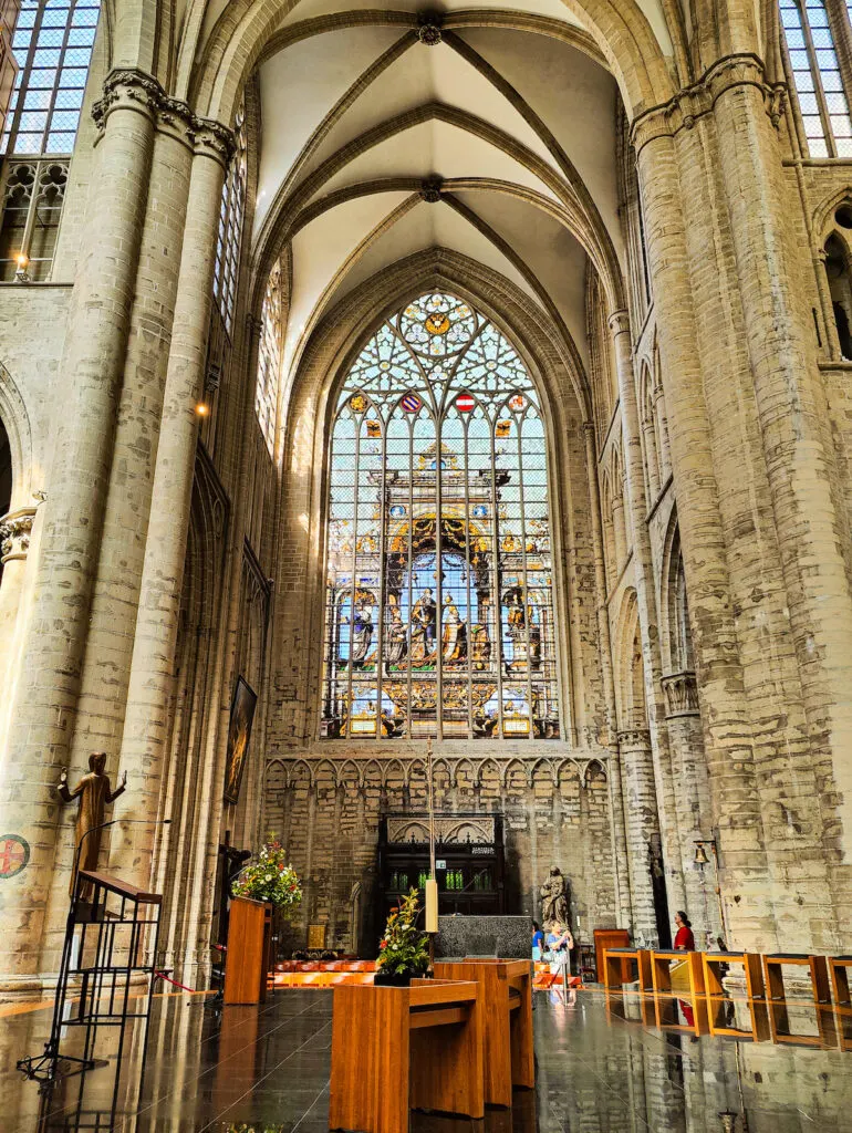 The interior of Brussels Cathedral with a large stained glass windpw. It is a must-see during s day in Brussels. 