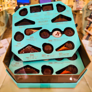 Turquoise box of chocolates from Neuhaus that detail the history of one of the best chocolate shops in Brussels.