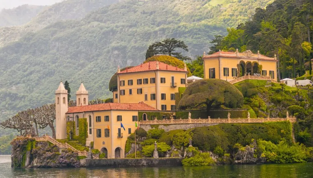 A view of a historic, yellow villa sitting on the shores of Lake Como.