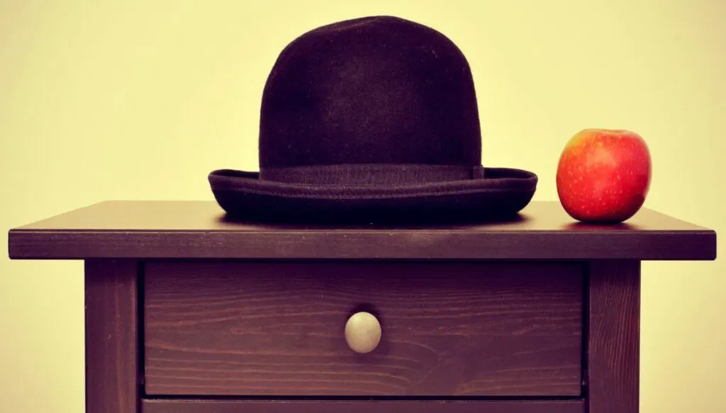 One of the best museums in Brussels has the Son Of Man painting at the Magritte Museum. It features a black top hat sitting on a small wooden night stand with a red apple to the right of the hat.  