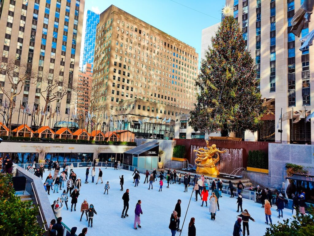 View of the Ice Skating Rink at Rockefeller Center. Skaters glide past the giant Christmas here.