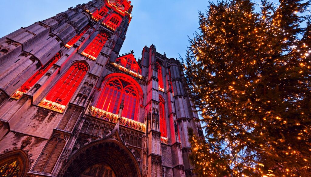 A view of the Cathedral of Our Lady Church all lit up with pink lights in the evening in Antwerp. 