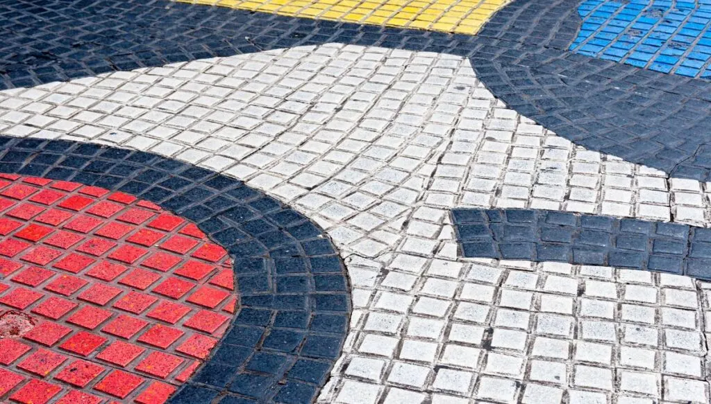 View of red, white, black, yellow, and blue tiles that make up a tile mural by Joan Miro on the ground on Las Ramblas.