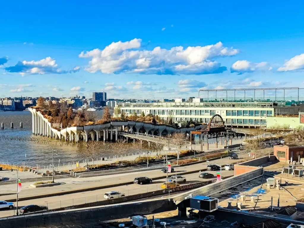 An aerial view of Little Island in Chelsea. This is the view of this raised platform park with trees in the water. It is a view from the roof of the Whitney Museum.