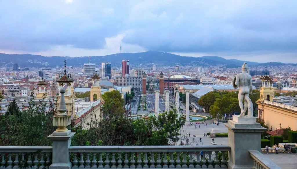 A birds eye view of Barcelona from the rooftop of Palau Nacional in Barcelona. You can see the Magic Fountain as you look down at the city from the rooftop on an overcast day. 
