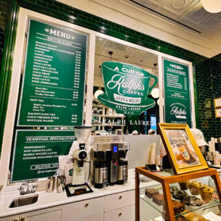A view od the vibrant green menu with white letters and the Ralph's Coffee logo in the center of the mirror. It's one of the cutest coffee shops on the Upper East Side.