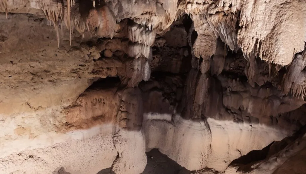 View of a walkway through a white cave with rock formations on the top of the cave in Texas. 