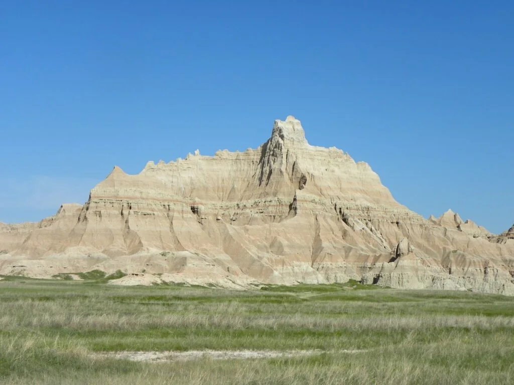 View of austere gray rocks in Fossil Butte National Monument with grass in the foreground. 