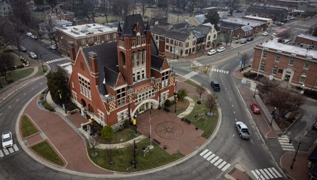 Aerial view of a historic brick building in the center of a roundabout in Bardstown. 