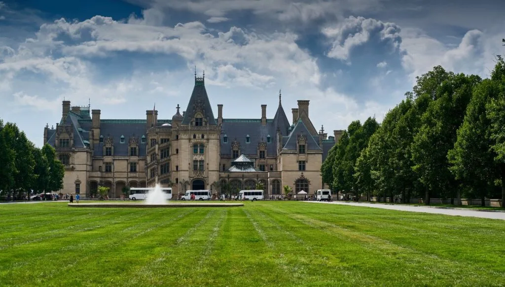 View of the Biltmore Estate with vans out fron and a fountain in front of a castle-like building. 