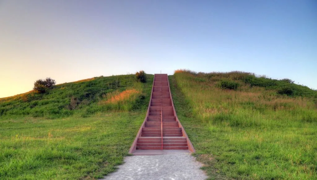 View of a set of red steps leading to the top of one of the Cohokia Mounds around sunset. 