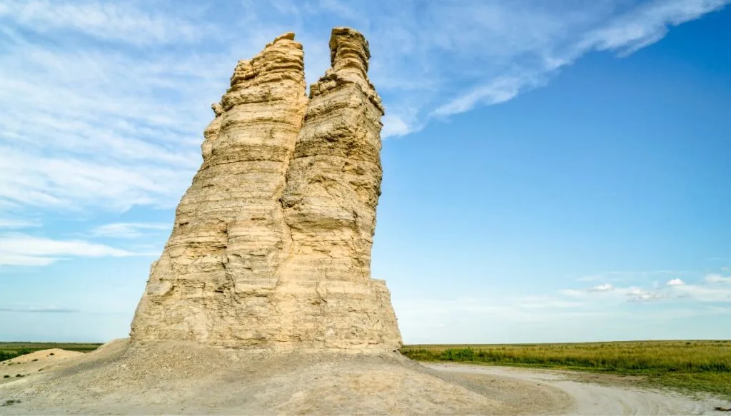 View of the white, column-like Castle Rock set against the backdrop of the endless prarie in the background. 
