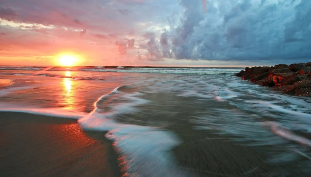 View of the sunrise over Folly Beach with the waves coming ashore. This is one of the most beautiful places in South carolina. 