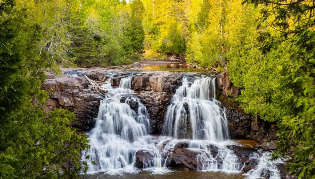 Aerial view of Gooseberry Falls surrounded by green trees. 