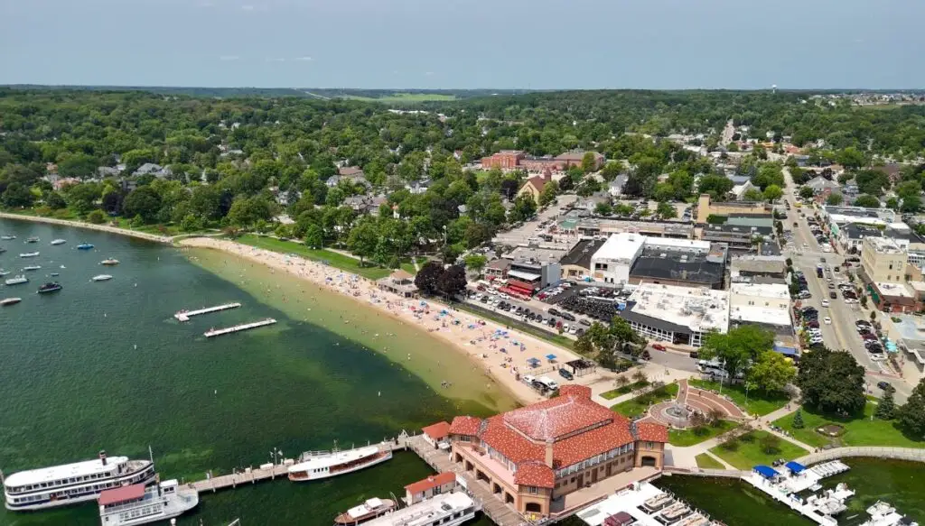 Aerial view of a beach along Lake Geneva with tons of buildings in the background. 