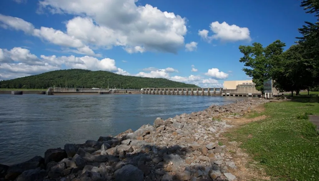 View of the rocky shores of Lake Guntersville with the Guntersville Dam in the background. 