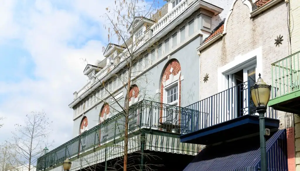 View of a historic home in Mobile with a balcony and a Colonial-style, lihgt blue facade. 