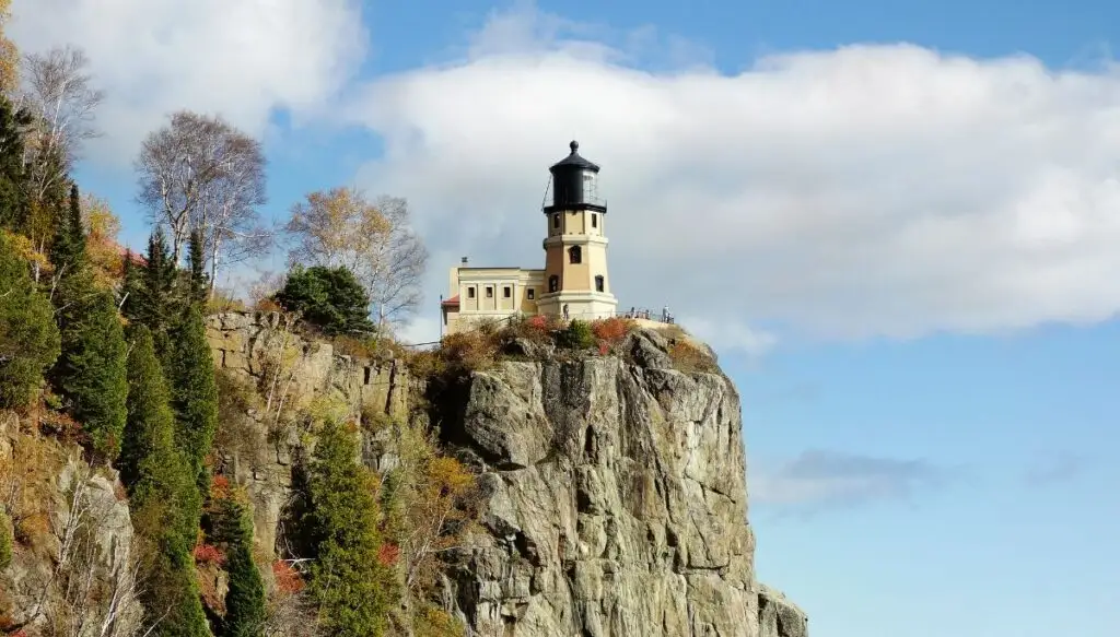 View of a white lighthouse sitting along the edge of a cliff. This is Split Rock Lighthouse and it is one of the most beautiful places in Minnesota. 