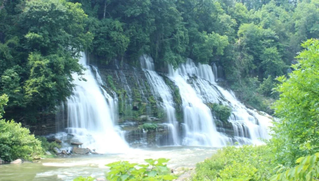 View of Twin Falls in Tennessee which is surrounded by green trees. 