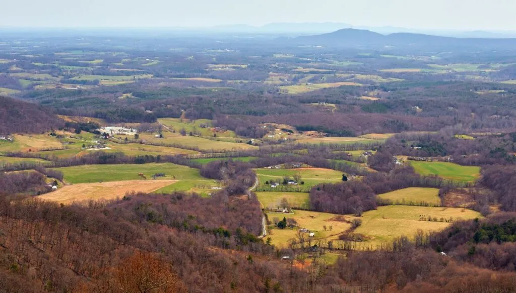 View from the Blue Ridge Parkway with barren trees and fields  with green grass and houses on 