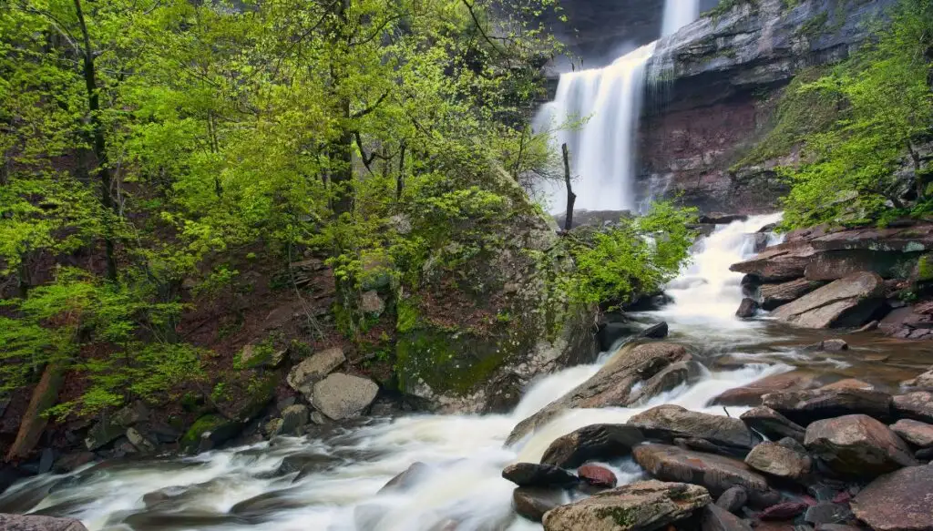 View of a series of small waterfalls tumbling down rocks surrounded by trees at Kaaterskill Falls. This is one of the most beautiful places in New York state. 