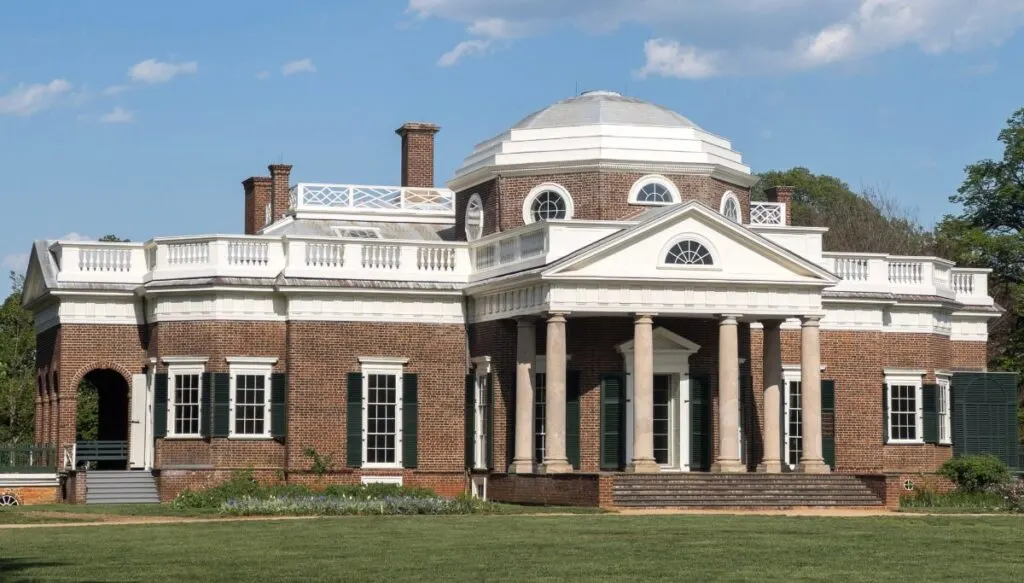 View of the brick exterior of Monticello with a domed roof and Columns in the front. 
