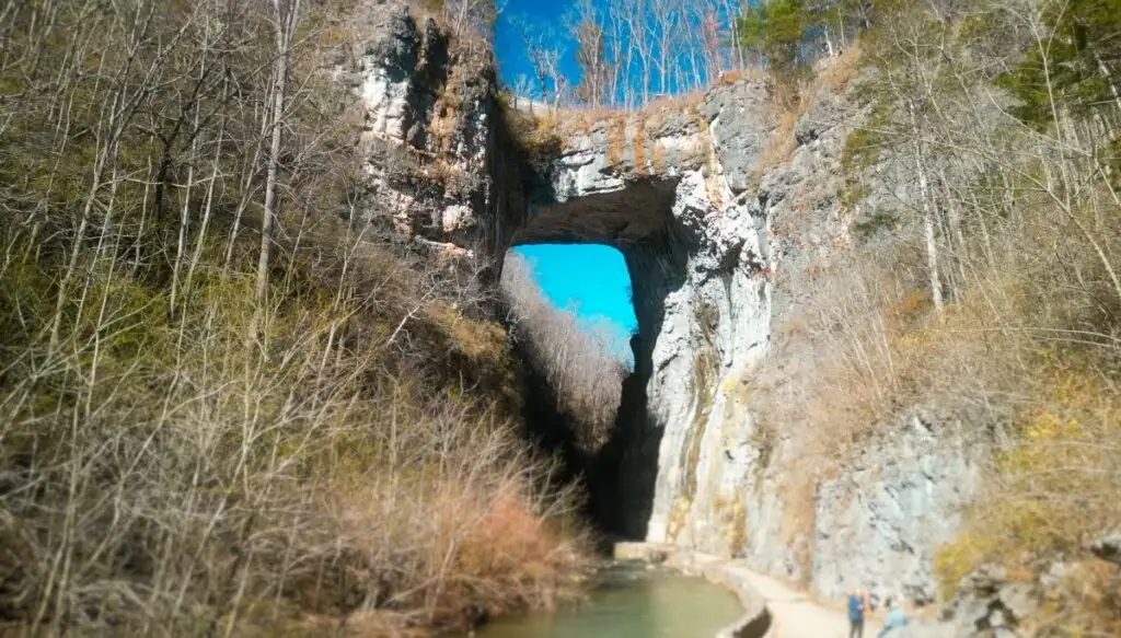 View of a natural stone bridge sitting above a river in Natural Bridge State Park 