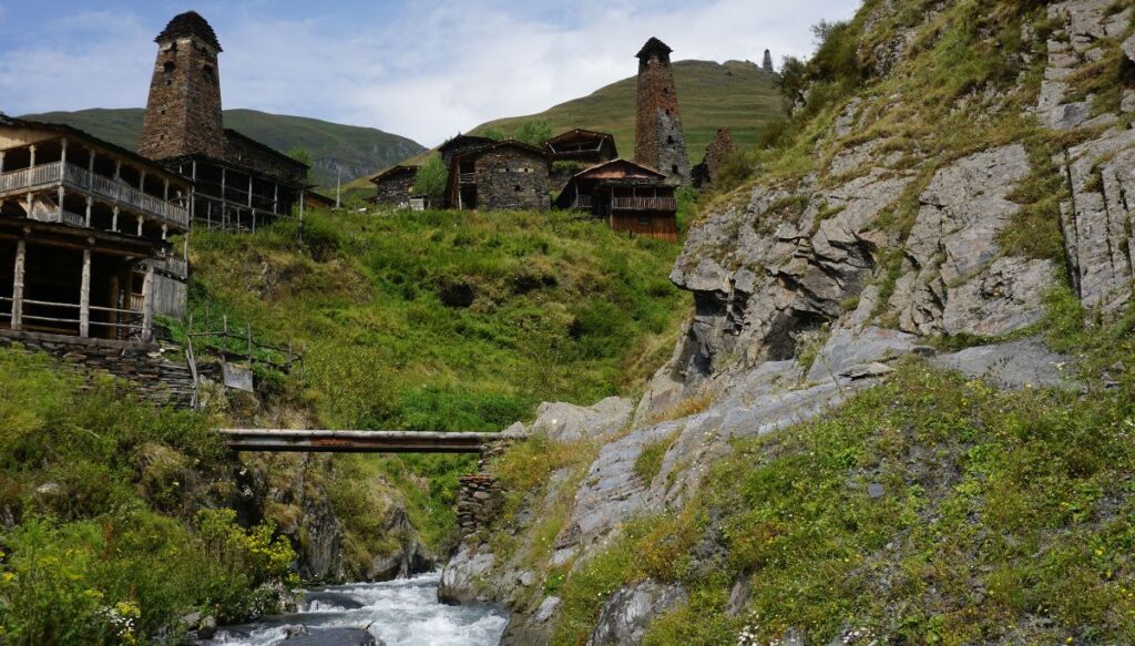 View of a small bridge over a stream with stone columns and houses in the mountains in Dartlo. 