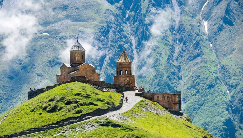 View of Gergeti Trinity Church with the green mountains all around it. 