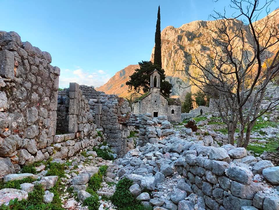 View of some of the ruins of Kotor Fortress with a stone church in the background. 