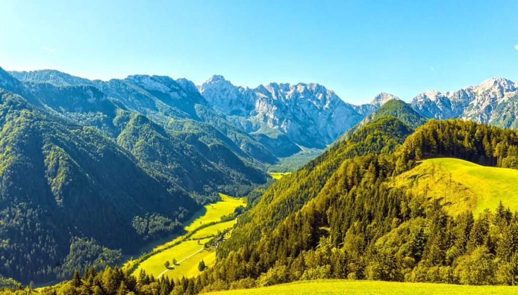 View of the bright green mountains that surround the Logar Valley on a sunny day.