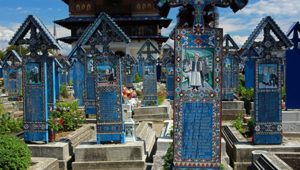 View of blue headstones with vibrant pictures and colors at the Merry Cemetery in Romania.