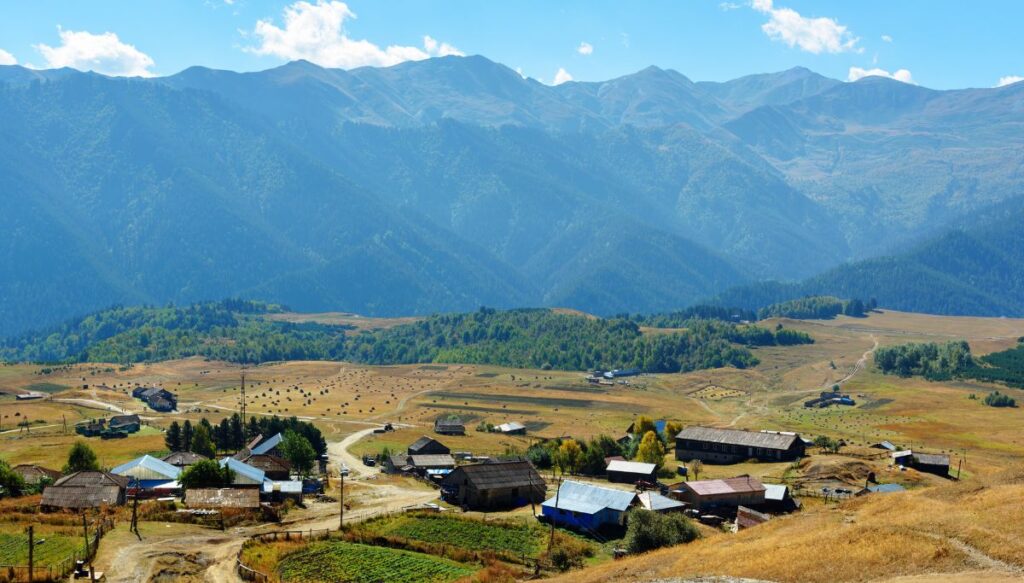 View of the small village of Omalo sitting in the valley surrounding by mountains in Georgia. 