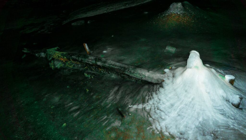 View of ice sitting in a mound inside of Scărișoara Ice Cave.