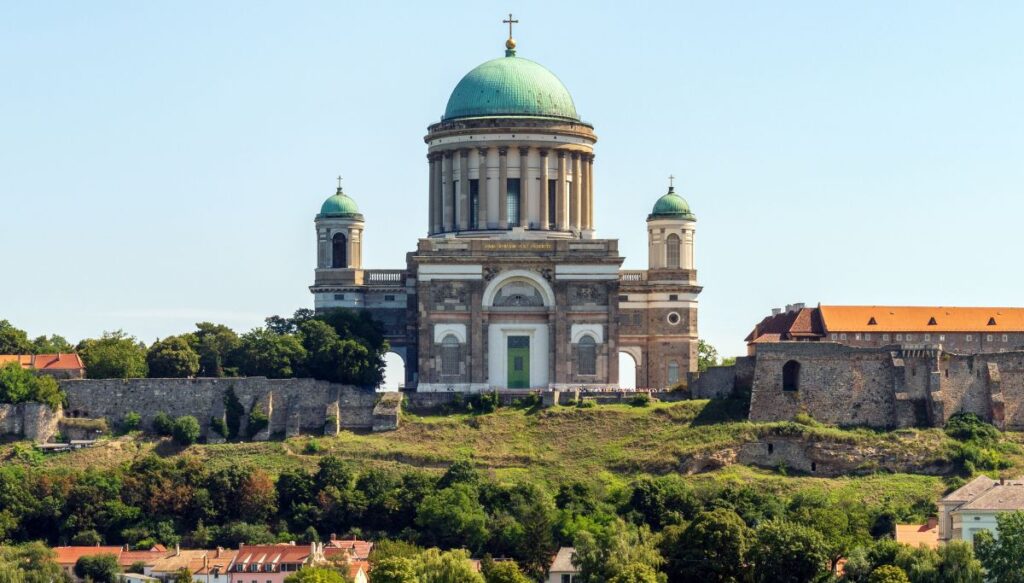 View of Esztergom Basilica with it's green dome and two green topped towers on either side of the stone cathedral in Hungary.