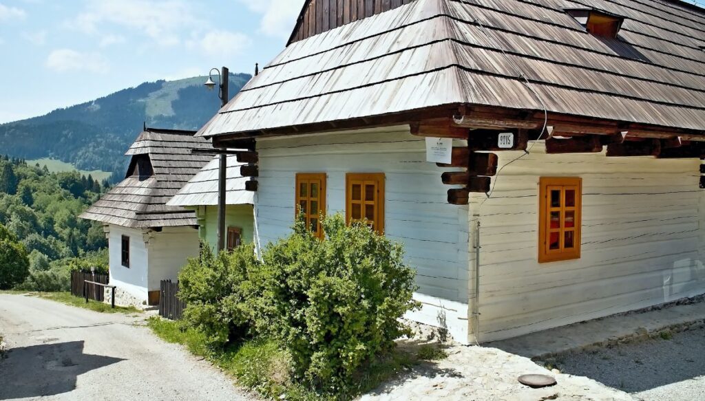 View of the unique white homes with folk architecture inside the small mountain town of Vlkolínec in Slovakia.
